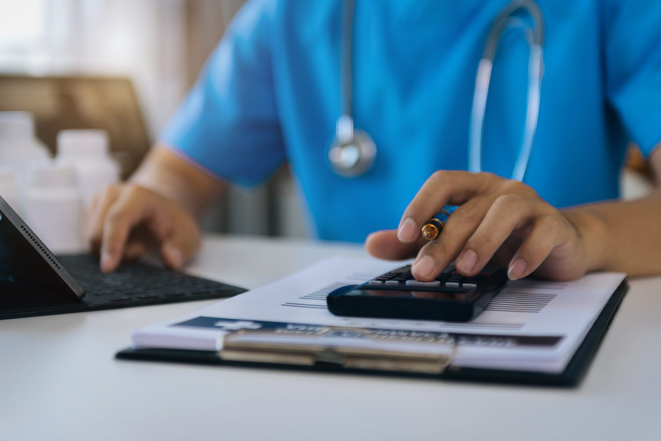 Doctor with calculate medical fee costs & revenue. practitioner use calculator at clinic.
